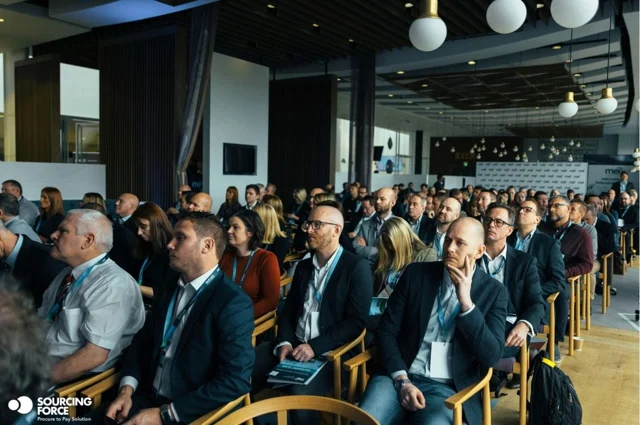 Participants assistant à une présentation en salle.